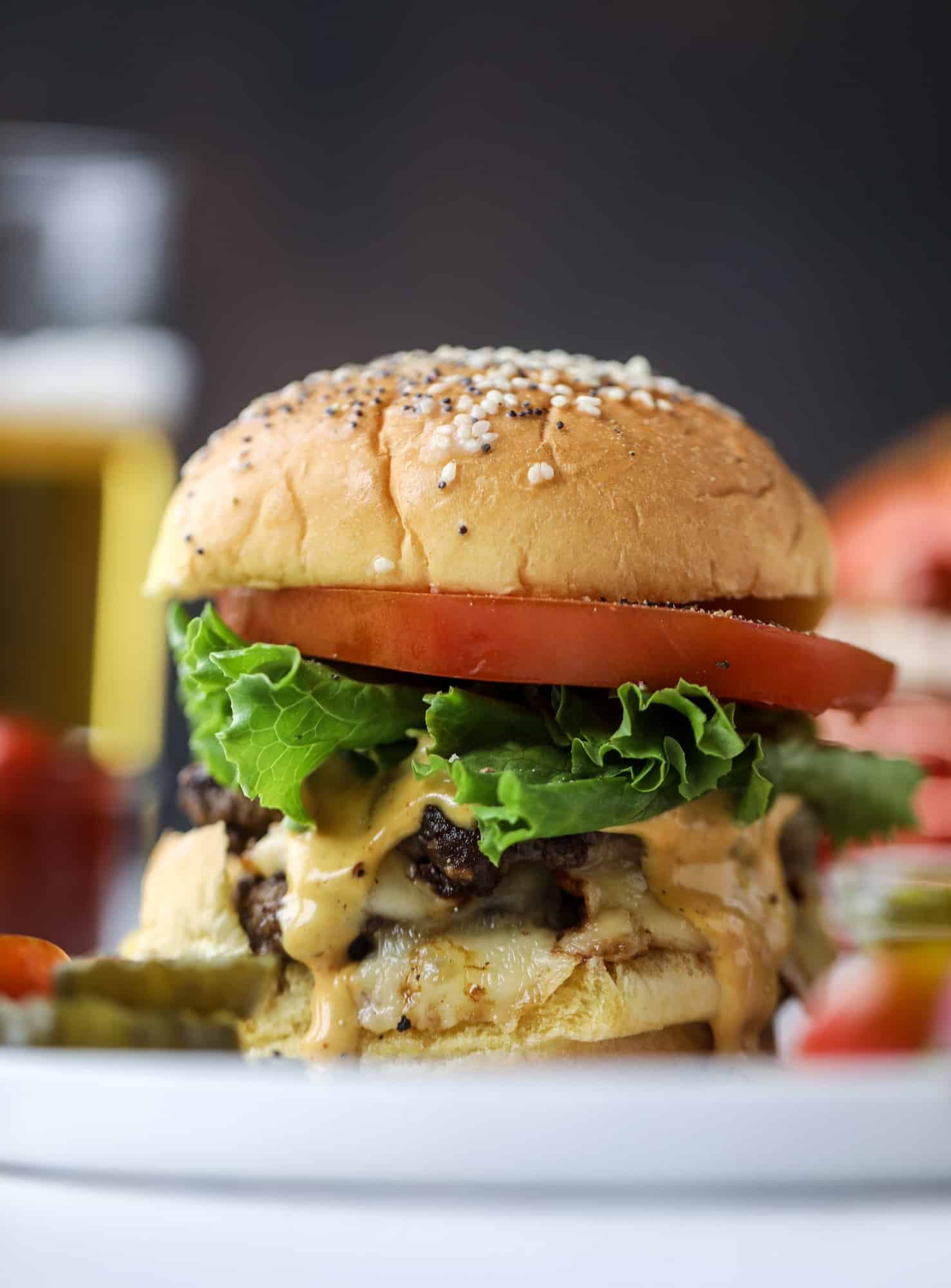 These smash burgers are to die for! All you need are a few ingredients and 30 minutes to make these smash burgers happen. Topped with melty smoked gouda and topped with a creamy, tangy house sauce, these are the best burgers ever! I howsweeteats.com #smash #burgers #smoked #gouda #special #sauce
