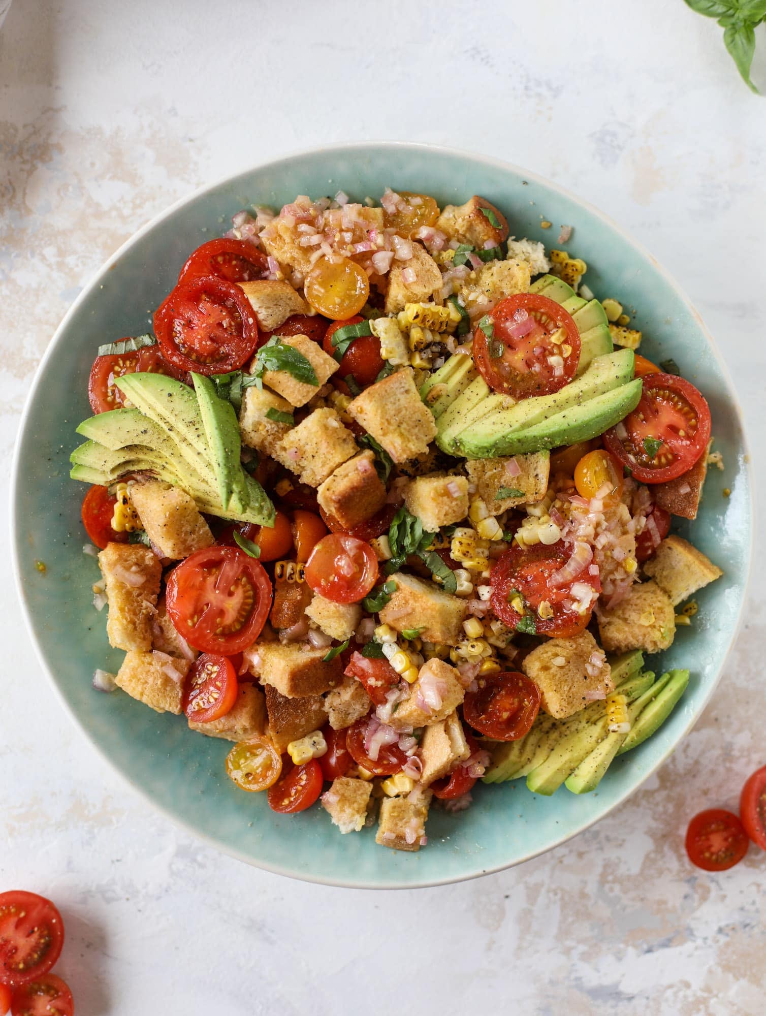 This is the perfect tomato panzanella salad! It's full of juicy, bursting, sweet tomatoes, toasted sourdough bread cubes, fresh herbs, grilled corn, sliced avocado and an incredible homemade dressing that blankets everything in deliciousness. SO good. I howsweeteats.com #panzanella #salad #tomato #basil #summer #corn #avocado #healthy #recipes