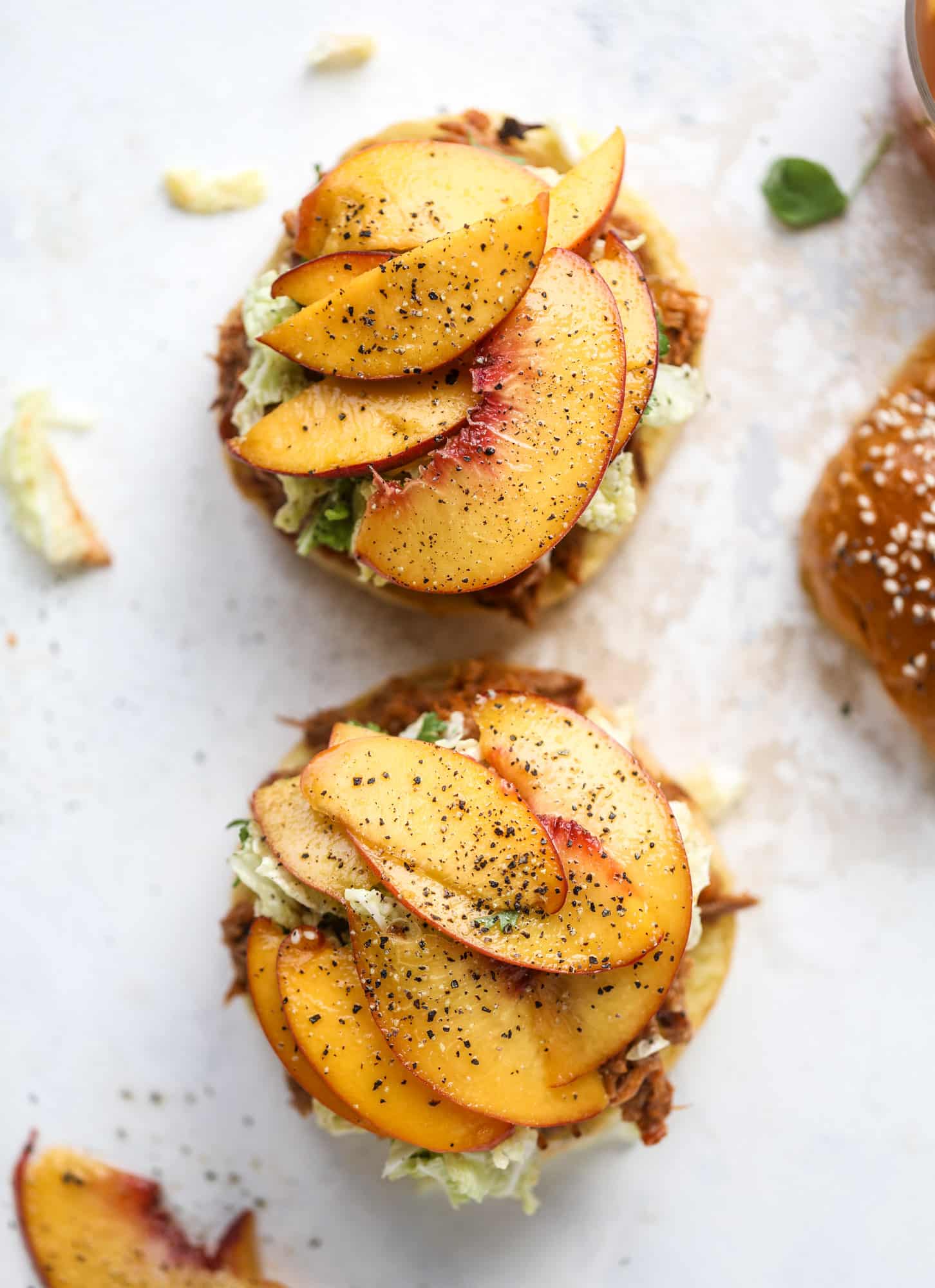 This chipotle pulled pork sandwich is spicy, sweet and saucy. Throw it on a bun or a plate and top it with the most delicious quick pickled peaches and napa cabbage slaw. Flavor and texture make this sandwich incredible! I howsweeteats.com #pulled #pork #chipotle #pickled #peaches #slaw #sandwiches #slow #cooker