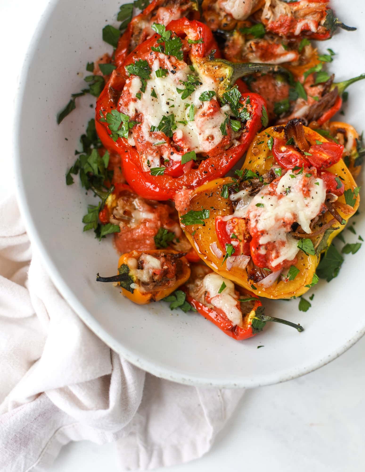 These pulled pork stuffed peppers are a delicious dinner idea for any weeknight! They work great with leftover pulled pork and the filling is totally customizable. They are flavorful, come together quickly and always a crowd pleaser! I howsweeteats.com #pulledpork #stuffedpeppers