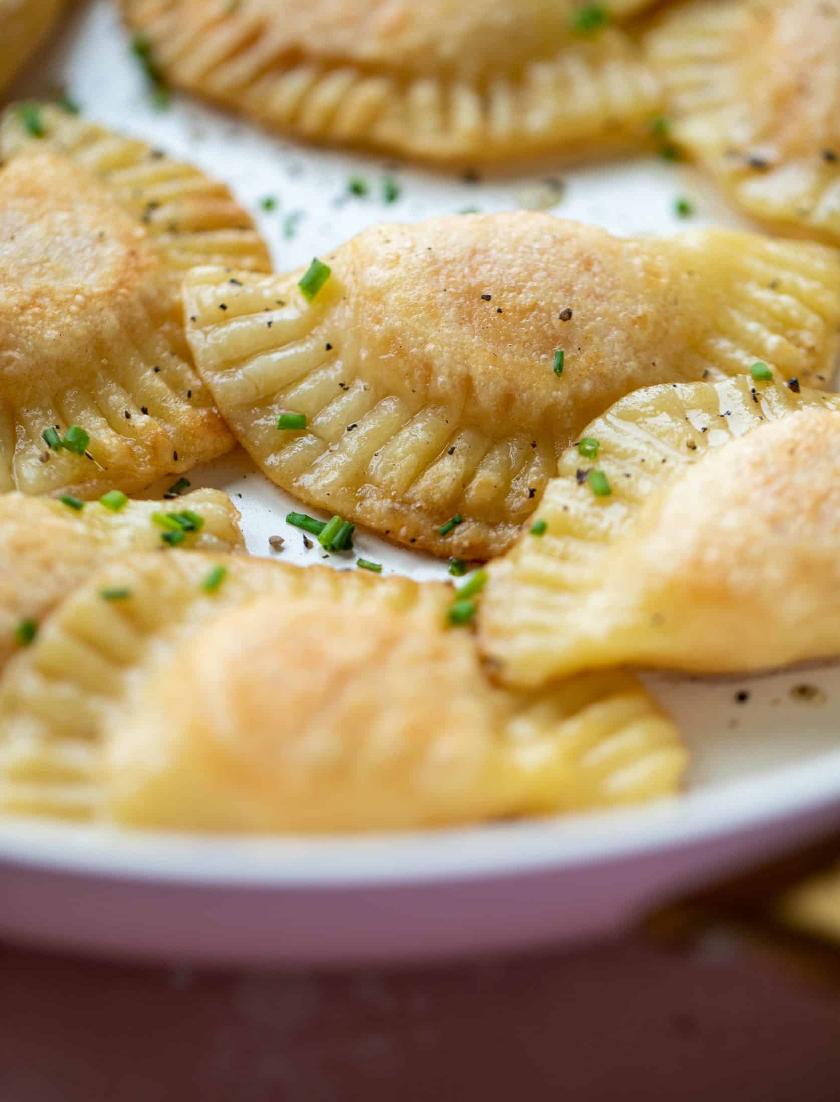The most delicious sweet potato pierogi recipe! Roasted sweet potato and fontina cheese in pillowy dough. Make sure to serve with brown butter!