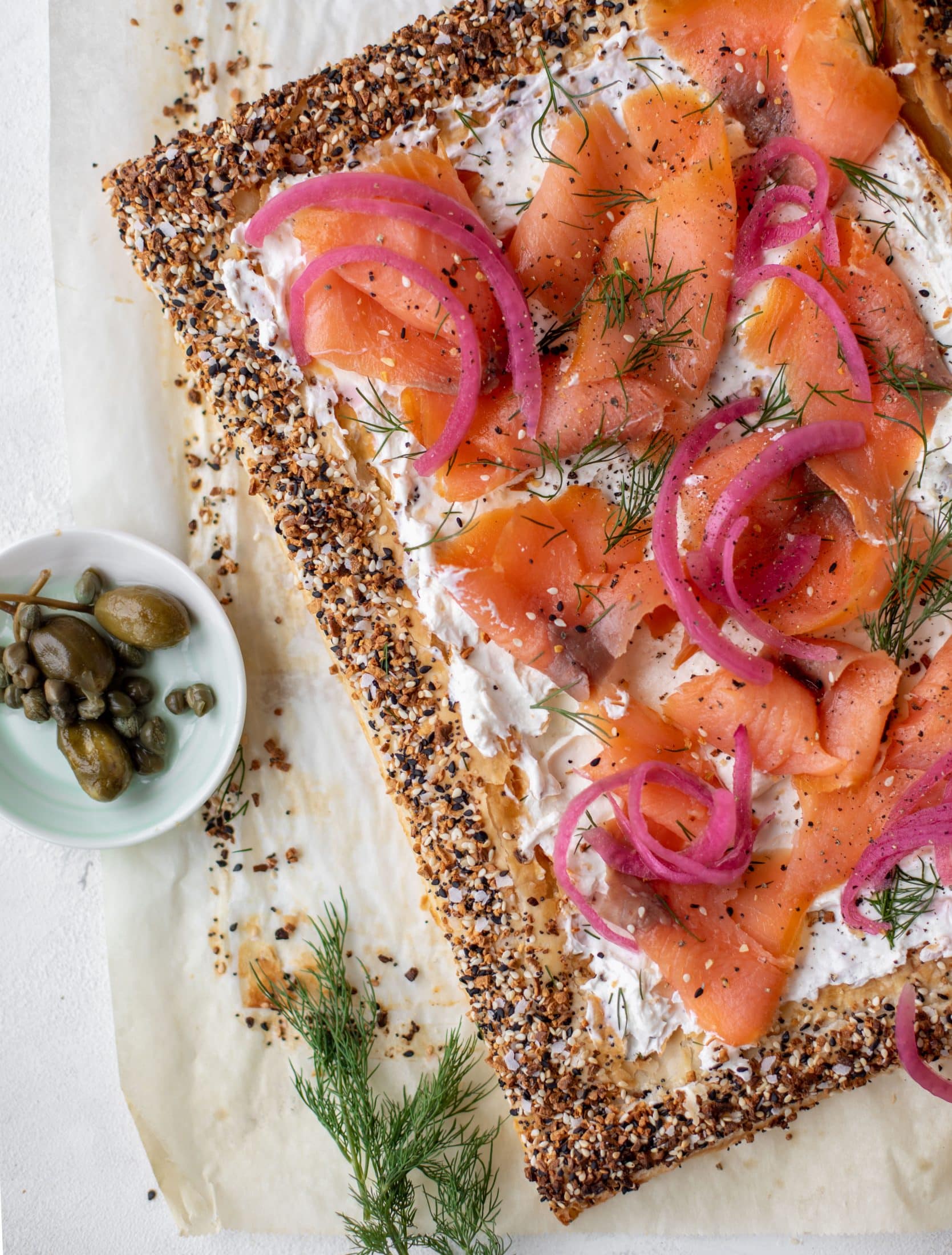 This everything smoked salmon tart is perfect for brunch! Puff pastry sprinkled with everything seasoning, slathered in cream cheese and topped with salmon.