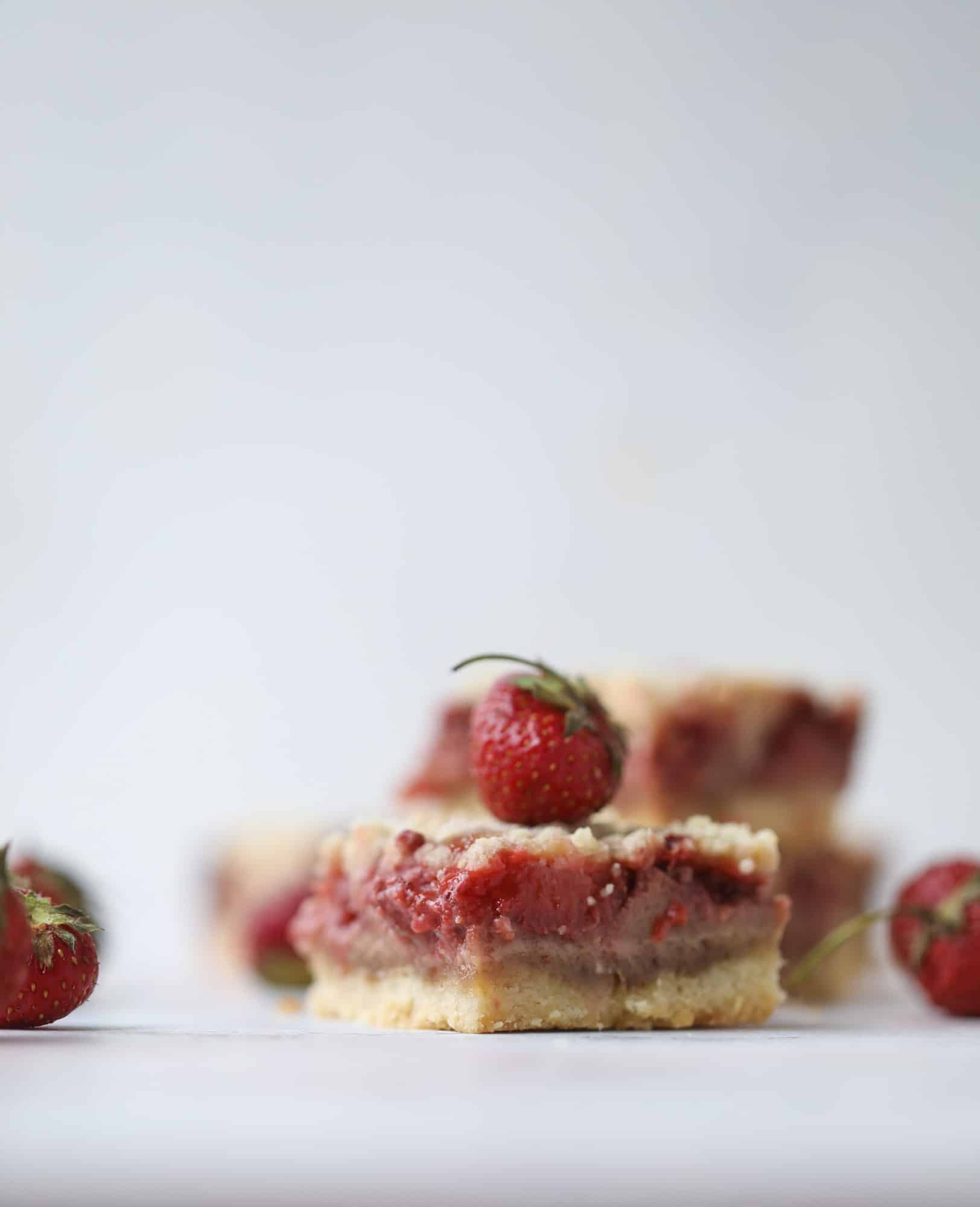 These strawberry cobbler bars are super delicious and perfect for a crowd! Made with juicy fresh strawberries, they start with a shortbread crust and end with a crumbly topping with a warm and delicious fruity filling. Huge hit! I howsweeteats.com #strawberry #cobbler #bars