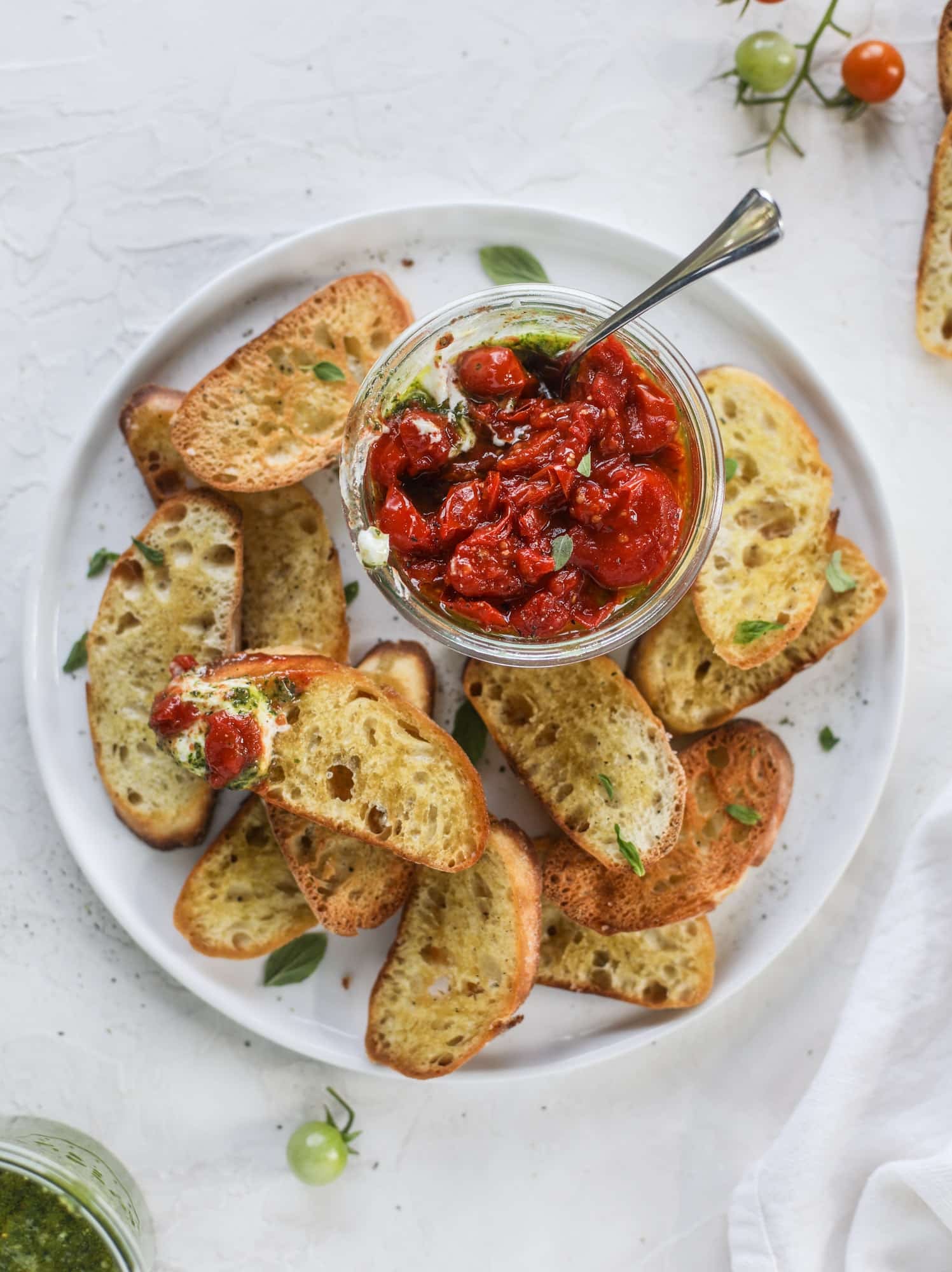 This ricotta jam jar is the perfect appetizer and snack to serve at a party! Based on the ricotta jam jar served at Nordstrom Cafe, it starts with creamy ricotta, is topped with flavorful basil pesto and a quick tomato jam. Serve with crunchy bread and dip dip dip! I howsweeteats.com #ricotta #jam #jar #nordstrom #tomato #pesto #appetizer #dip