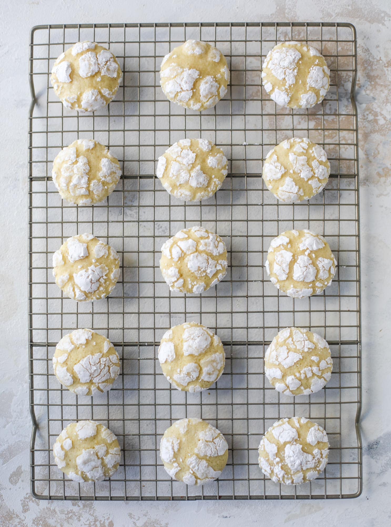 These lemon crinkle cookies are perfect if you love lemon desserts! They take after chocolate crinkle cookies, but are a delightful refreshing lemon flavor sprinkle with powdered sugar. These are always a huge hit! I howsweeteats.com #lemoncrinkle #cookies