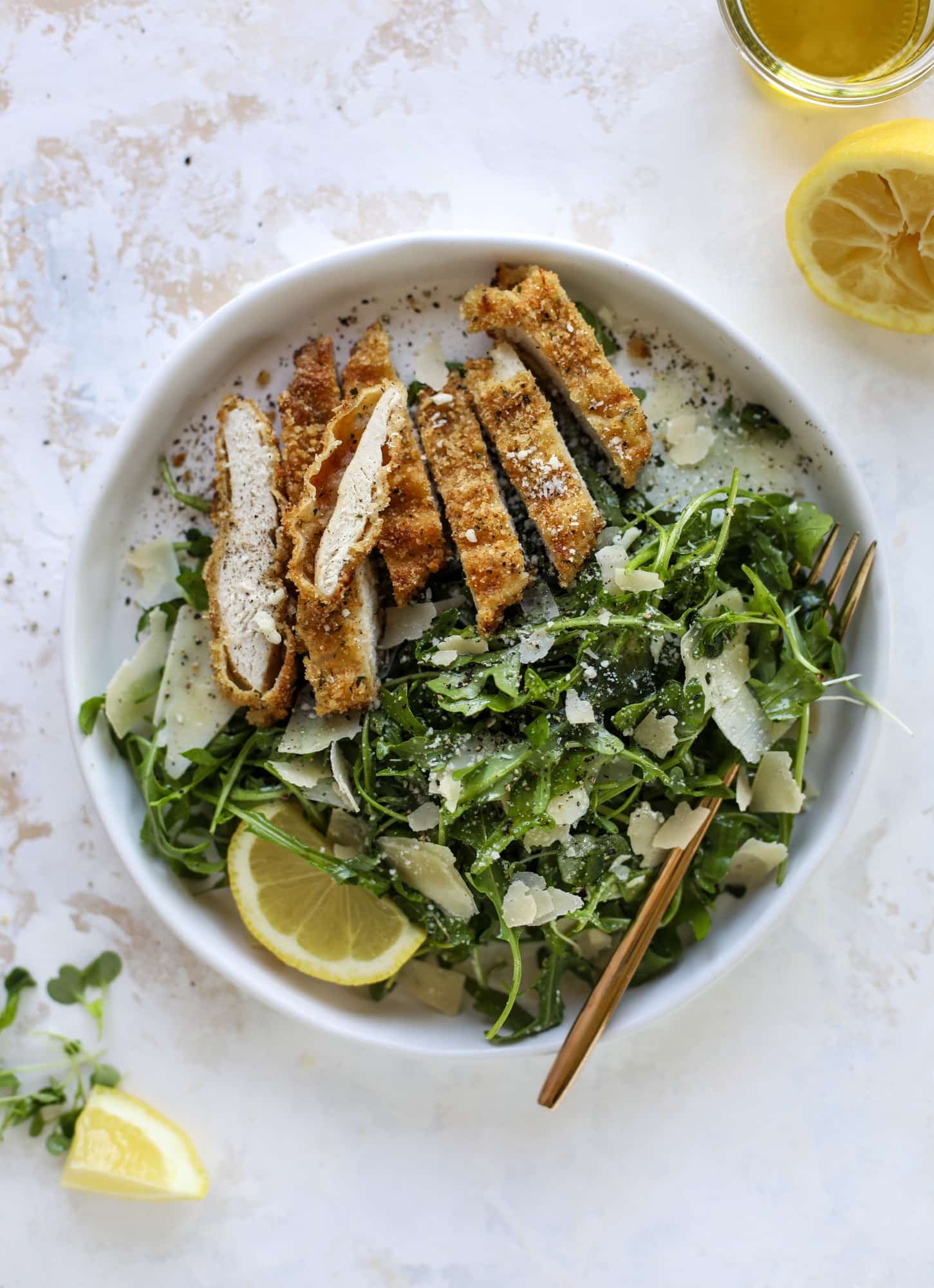 Crispy baked parmesan chicken is so super easy and delicious! It's an amazing weeknight meal served with a lemon arugula salad. Delish!