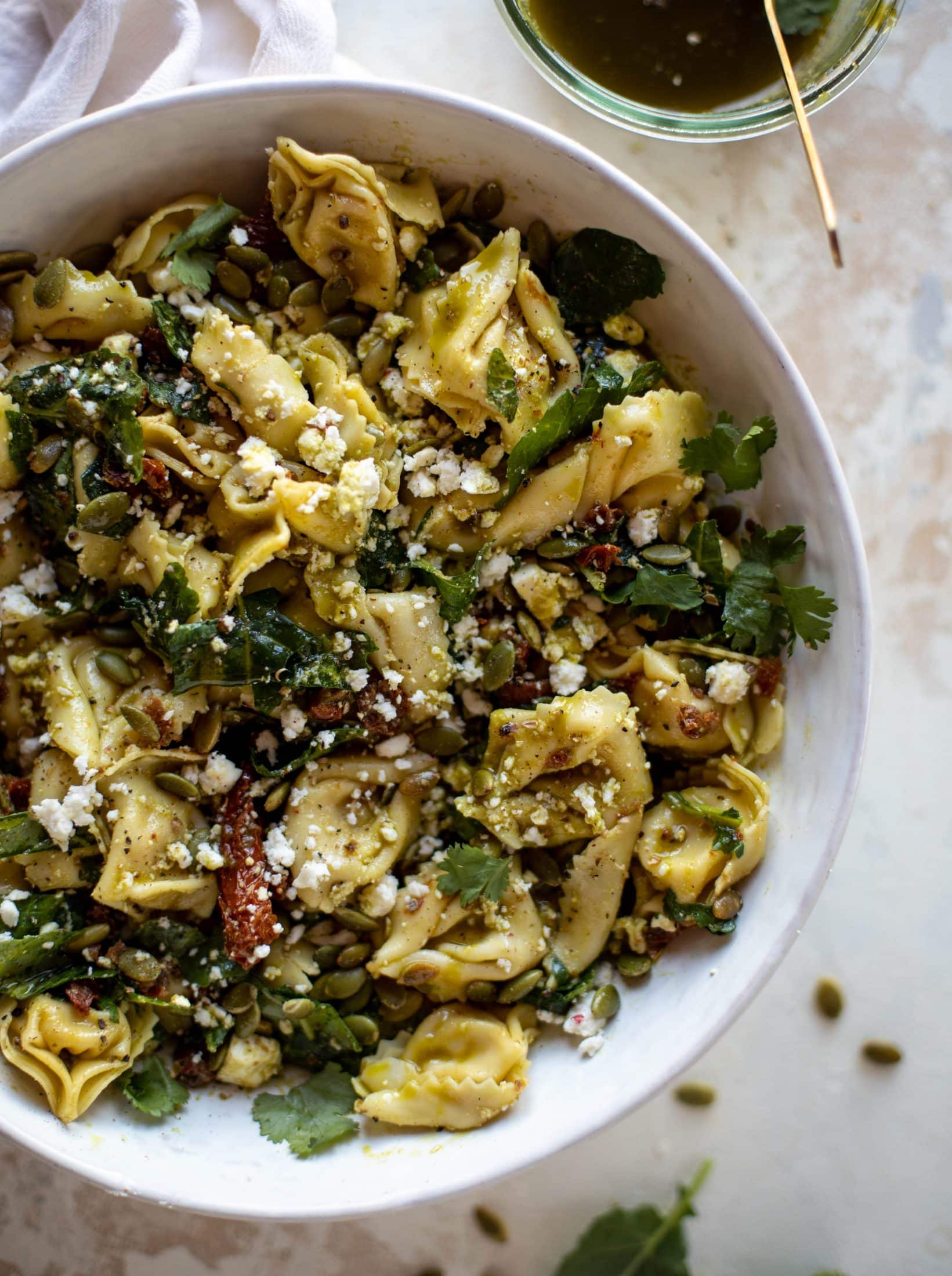 This cilantro lime tortellini salad is loaded with flavor! Served warm or cold, it has pepitas, sun dried tomatoes and crumbled feta. It's ridiculously good!