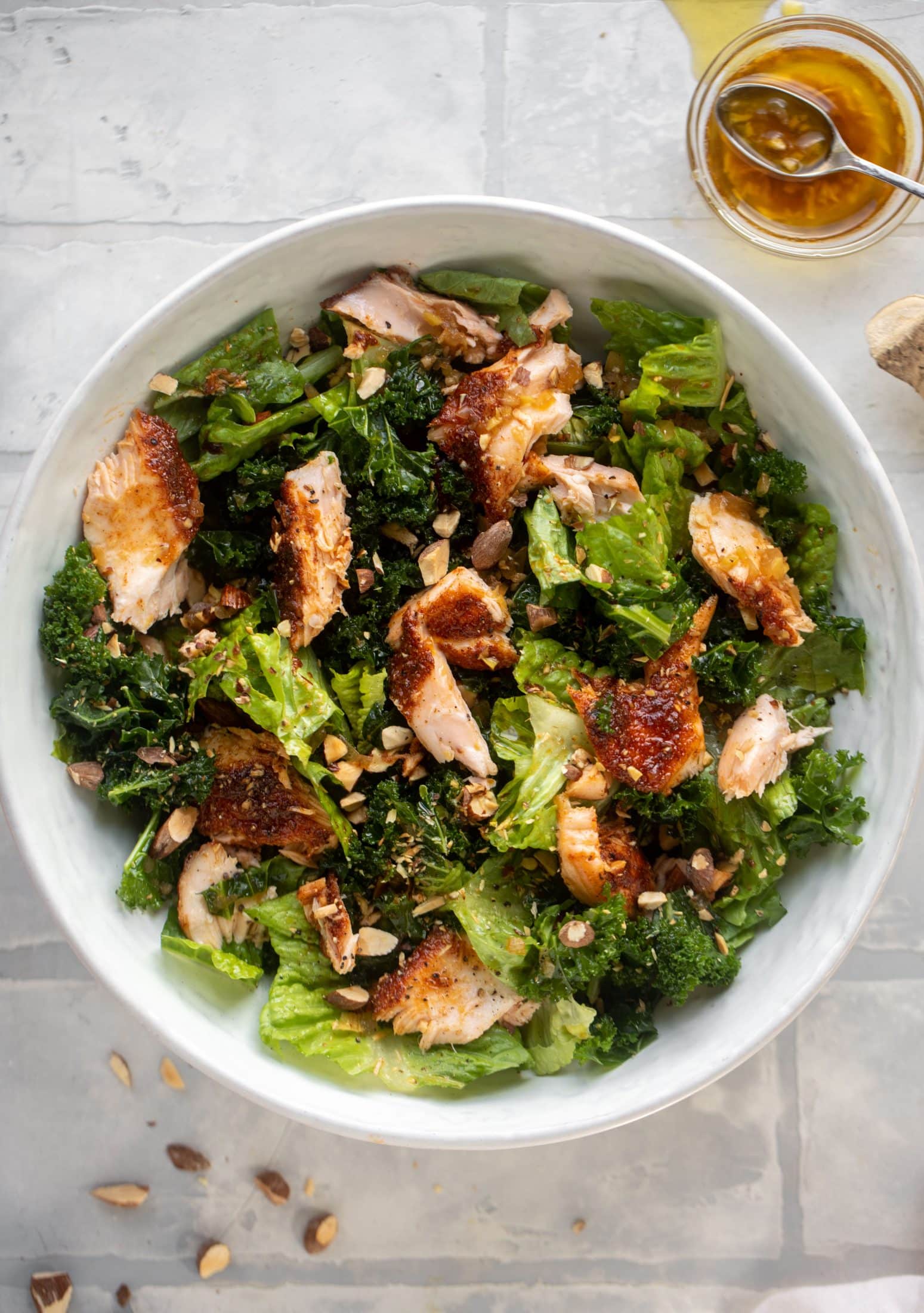 This ginger salmon salad has the flaky, flavorful roasted salmon on top of kale and romaine, drizzled with warm ginger vinaigrette. 