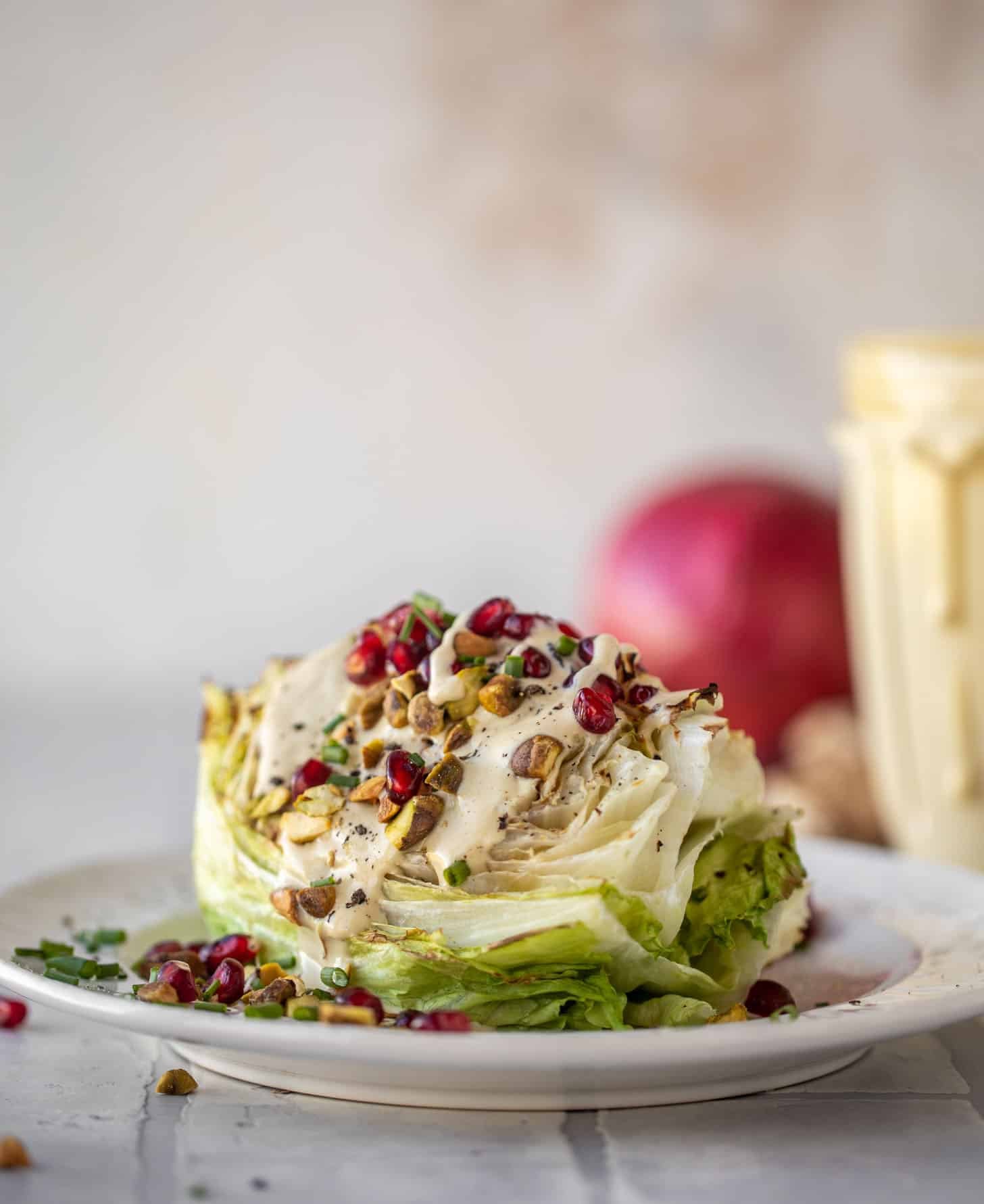 broiled wedge salad with pomegranates and pistachios
